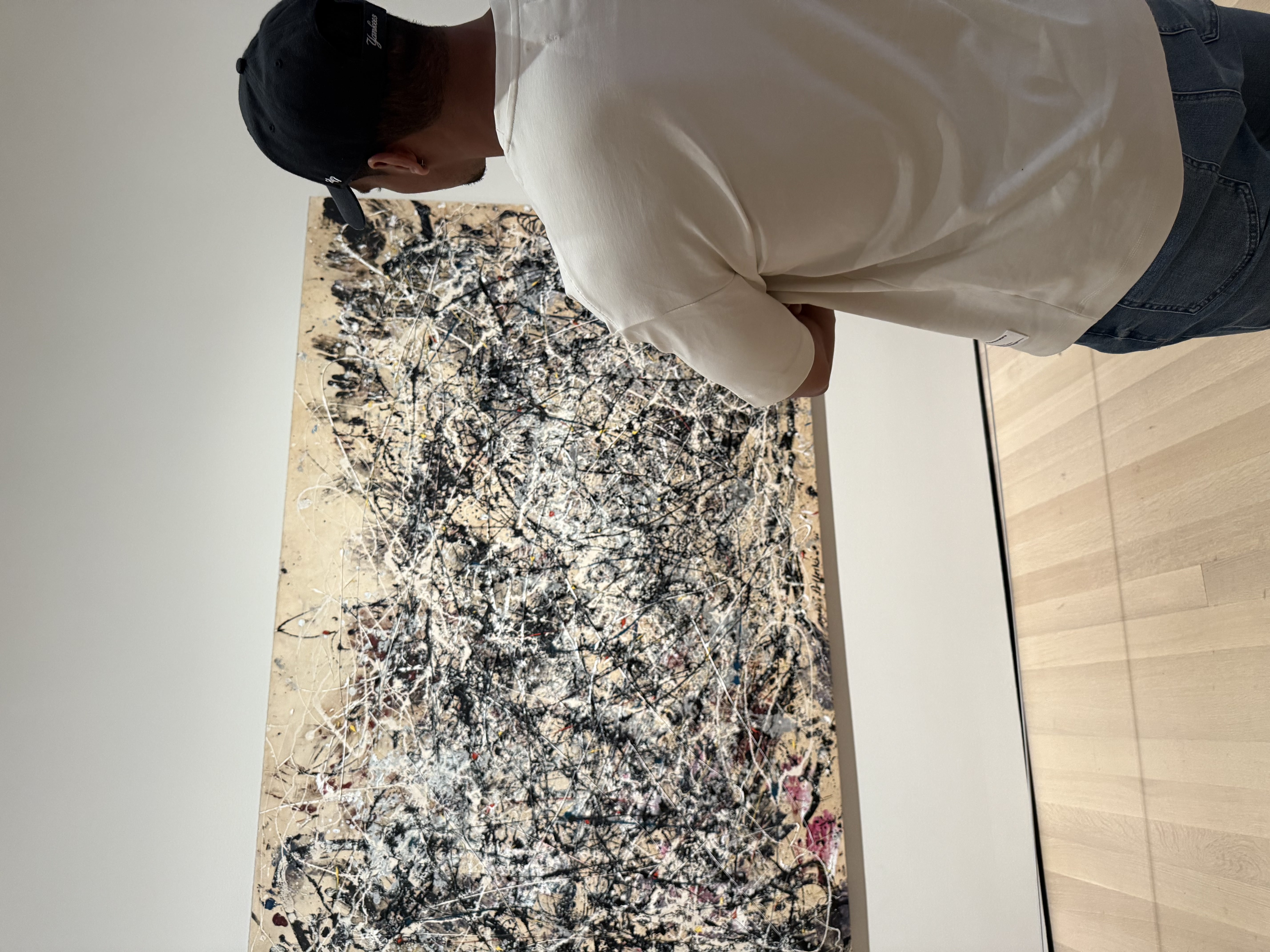 Artist viewing abstract expressionist artwork in a museum